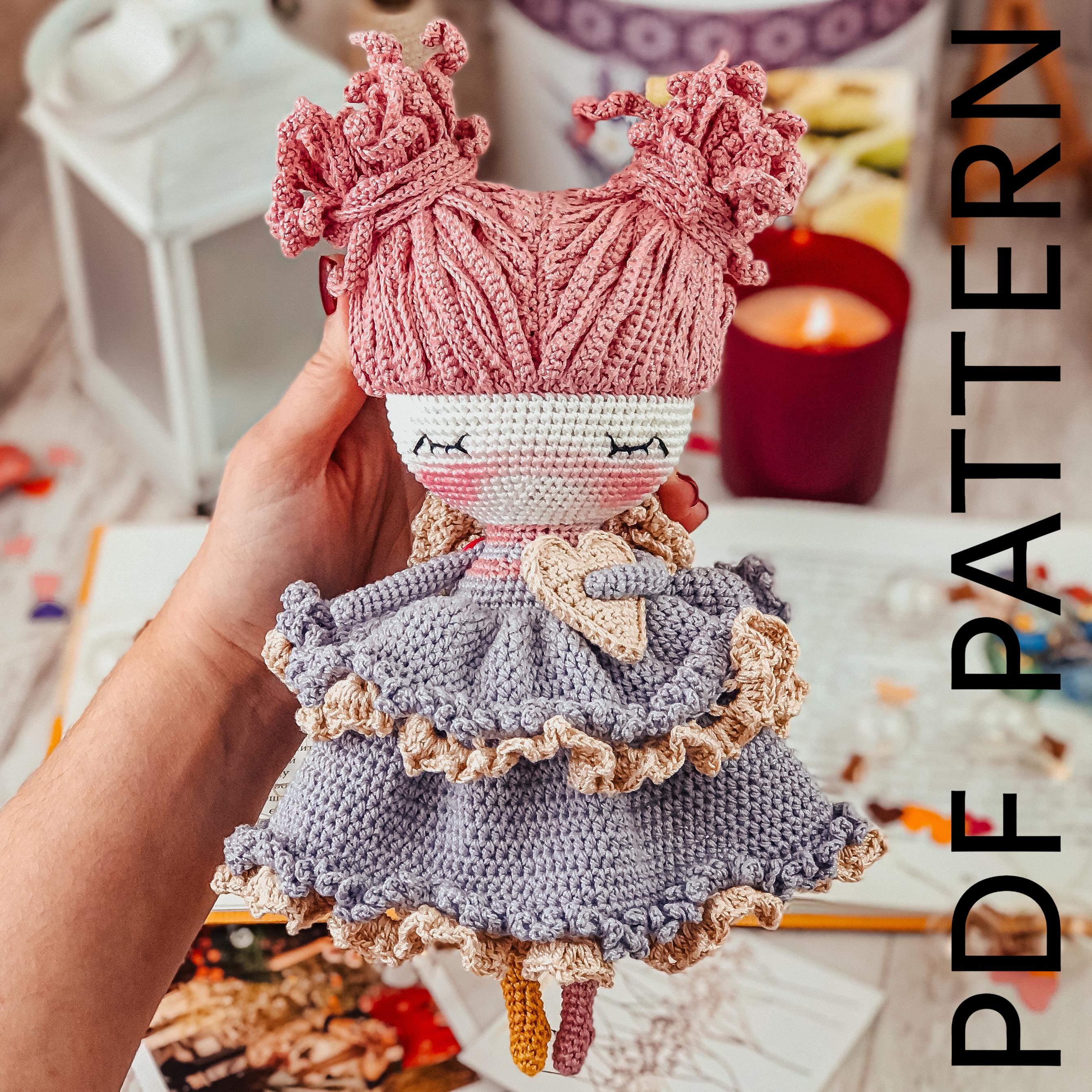 a hand holding a doll with a crocheted dress